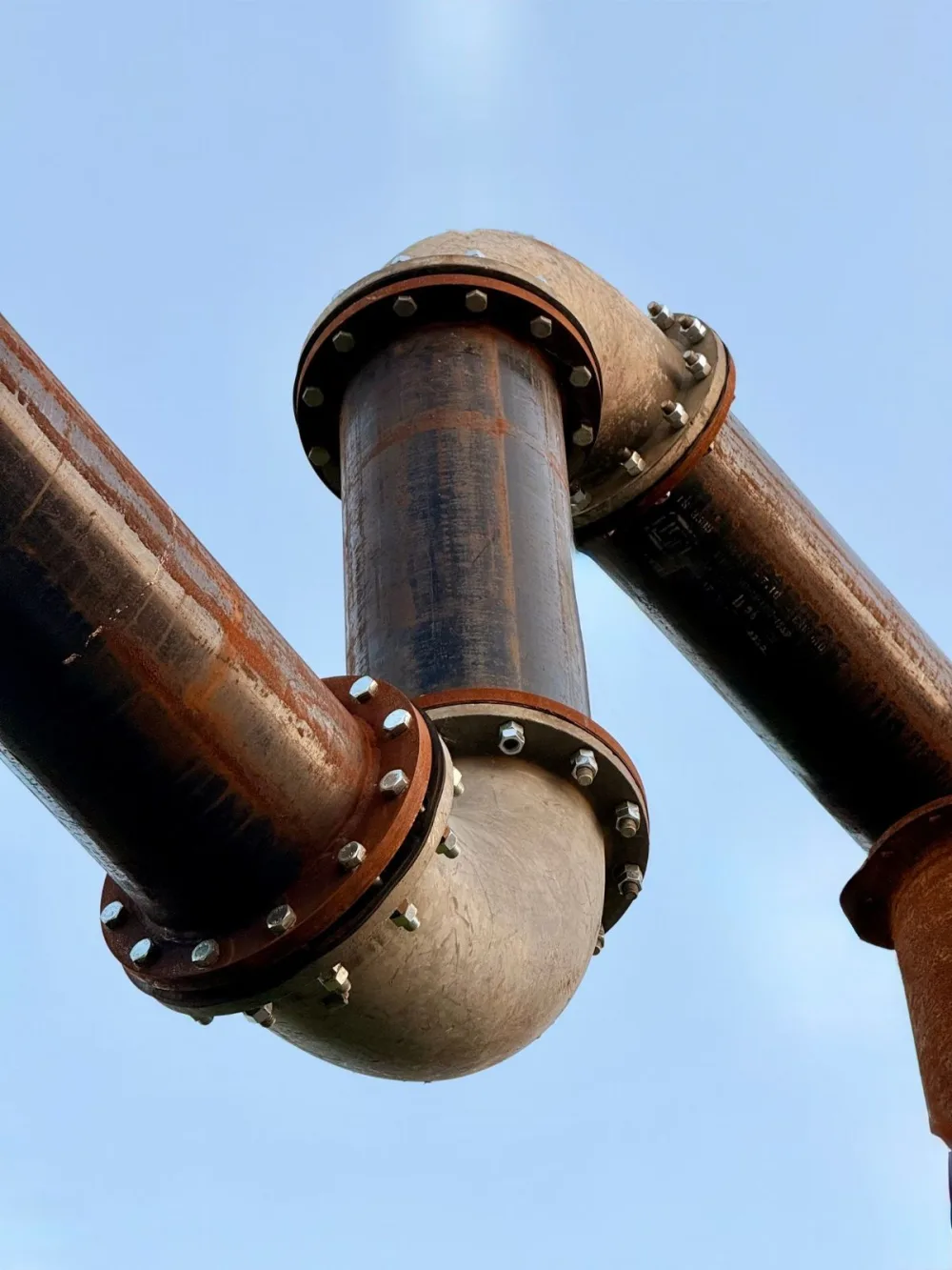 Large diameter pipes laid out against a clear sky